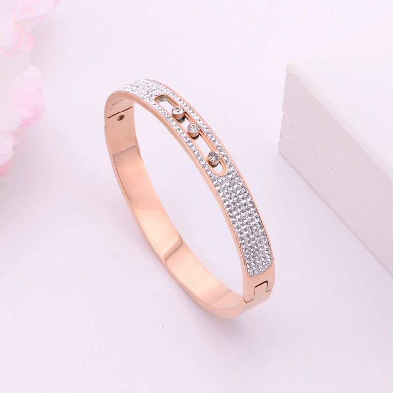 Rose gold titanium steel bracelet with three movable diamonds.