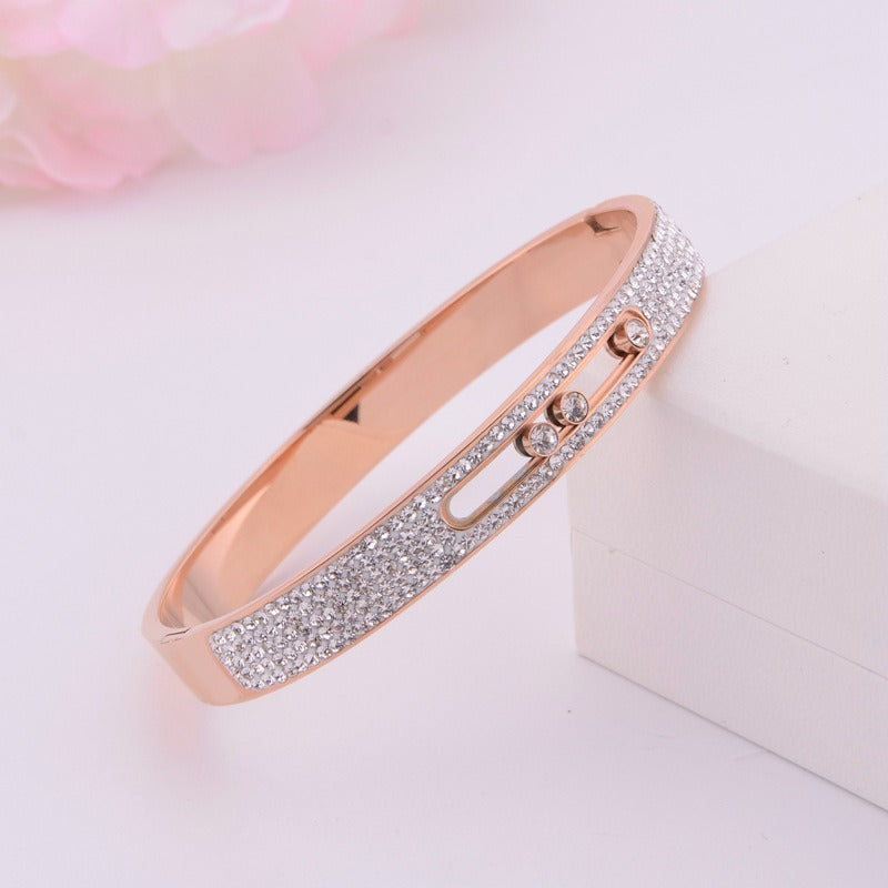 Rose gold titanium steel bracelet with three movable diamonds.